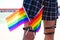 Girl`s leg detail with fishnet stockings and leather garters on which you can see two gay pride flags intertwined with each other