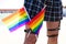 Girl`s leg detail with fishnet stockings and leather garters on which you can see two gay pride flags intertwined with each other