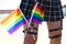 Girl`s leg detail with fishnet stockings and leather garters on which you can see two gay pride flags intertwined with each other