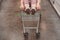 Girl`s legs stick out of the basket in the shopping hall of the supermarket. A teenager rides in a cart in an empty store