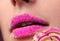 girl& x27;s lips with a lollipop over pink background