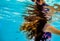 A girl`s long hair flowing underwater and reflections on the undersurface of the water