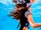 A girl`s long hair flowing underwater and reflections on the undersurface of the water