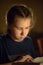 girl`s portrait with the book in reflected candle light