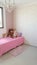Girl\'s room with pink details and some dolls and teddy bears on the bed