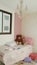 Girl\'s room with pink details and some dolls and teddy bears on the bed