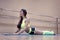 Girl`s workout on mat at dance hall background. Cute fitness woman lying on the exercising mat and lifting her chest