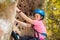 Girl in safety helmet climbing on the rock route