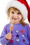 Girl in santa hat with a bright candy