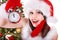 Girl in santa hat holding alarm o\'clock.