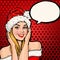 Girl in Santa hat with speech bubble on red background.