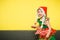 Girl in santa`s little elf`s dress gallops in hall on couch. child in Miss Santa`s hat with pigtails plays on Christmas night