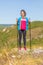 Girl with scandinavian sticks on top of the montain.