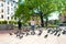 A girl scares a flock of pigeons in the city square