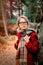 Girl in scarf and coat in a forest with rocks