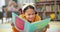 Girl, school and reading book in class, childhood development and growth for vocabulary in kindergarten. Happy, smile