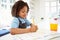 Girl In School Uniform Doing Homework In Kitchen