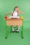 Girl in a school uniform sitting at a desk and yawns