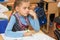 Girl schoolgirl sits at a school desk at lesson at school