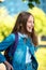 Girl schoolgirl. Summer in nature. In denim jacket behind a backpack. Happy smiling returns home. Joyful laughs after a