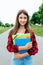 Girl schoolgirl teenager 10-15 years old, summer city after school lessons. In hands documents and notebooks notes