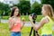 For girl schoolgirls, summer in nature. Records a video about healthy eating. In his hands holds a green apple and a