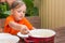 Girl scoop ladle porridge from the pot