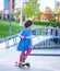 Girl with a a scooter in the skate park in summer