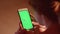 Girl scrolls smartphone with green screen and 3d tracking points