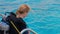 a girl with scuba diving is sitting on board a yacht, preparing to dive, diving in the sea