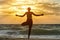 Girl on sea beach practicing yoga. Back view. Beautiful sunlight