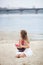 Girl on the sea with a ship. little girl wait boat with scarlet sail. The girl in the white board on the beach with scarlet sails