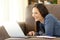 Girl searching online content in a laptop at home