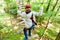 Girl seen from above climbing in high rope course