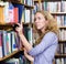 Girl selecting book from a bookshelf