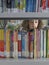 Girl Selecting Books From Library Bookshelf
