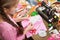 Girl sews doll clothes, top view, sewing accessories top view, seamstress workplace, many object for needlework, handmade and hand