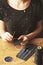 Girl sews medical masks on a wooden table. Threads. Needle in hand