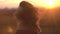 Girl shakes her hair in summer field. Beautiful woman shakes hair in sunset