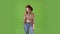 Girl in the shape of a cowboy is waiting for her friends and looks at her watch. Green screen