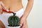 The girl shaves a large cactus with a razor in the groin area. The concept of intimate hygiene, epilation and depilation