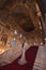 A girl in a shiny dress standing on the steps of a luxurious historical palace staircase.