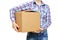 Girl in a shirt and jeans holds a large cardboard box. White isolate