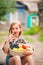 Girl in shirt and shorts with a basket of fruit. Girl farmer with apples and grapes. Concept of ecological food, person