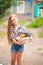 Girl in shirt and shorts with a basket of fruit. Girl farmer with apples and grapes. Concept of ecological food, person