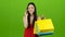 Girl is shopping with packages and talking on the phone. Green screen