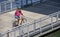 Girl in shorts rides a bicycle on a floating dock on the Willamette River, preferring an active healthy lifestyle