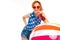 Girl in shorts and a t-shirt drinks a cocktail and leans on an inflatable ball on a white background