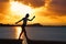 Girl silhouette at beach sunset gymnastics