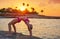 Girl silhouette at beach sunset gymnastics